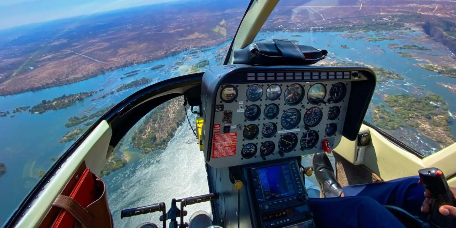 Helicopter approaching Victoria Falls — aerial perspective showing the full gorge system below