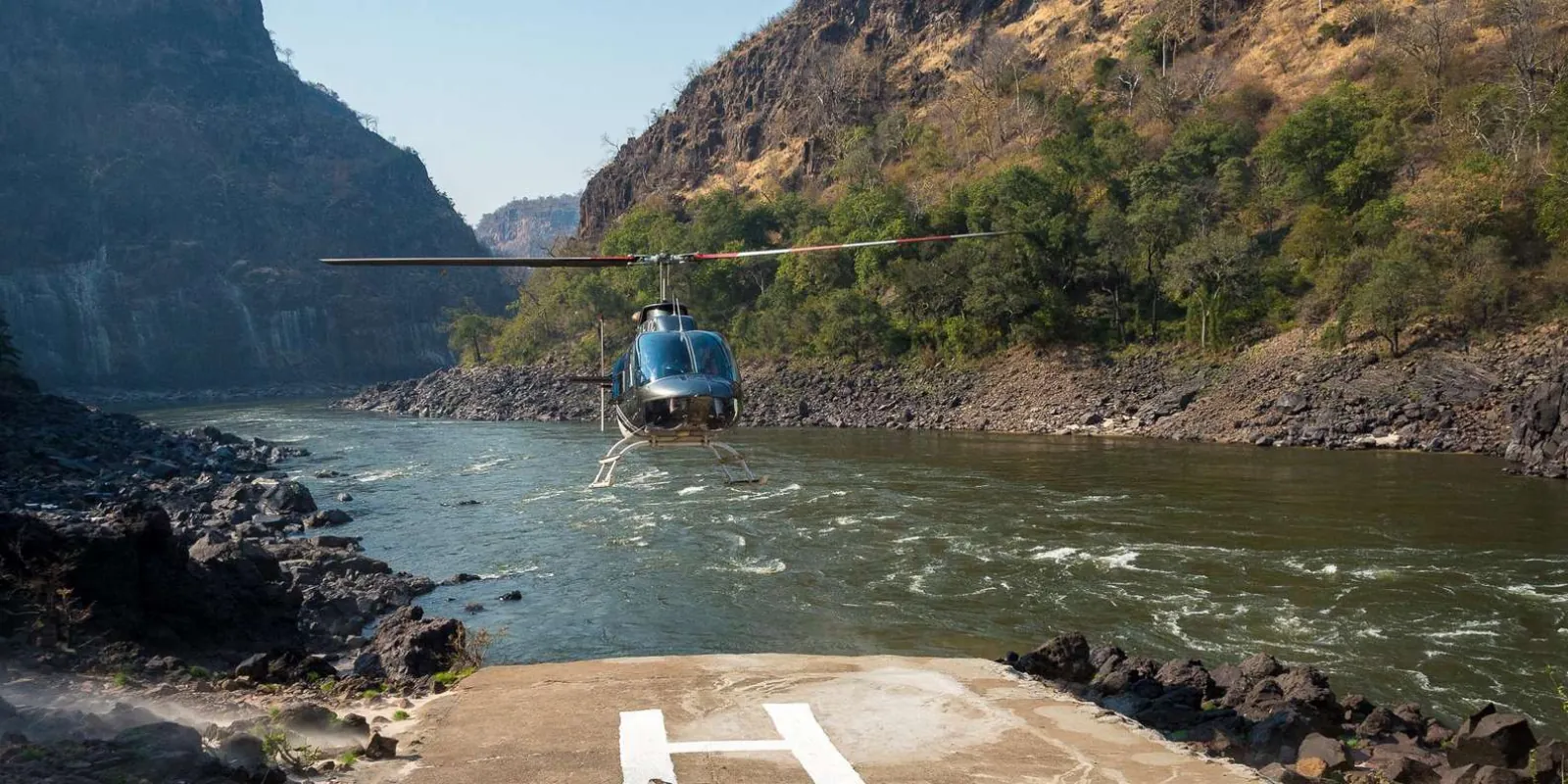 Helicopter ascending over Victoria Falls on the Livingstone, Zambia side — aerial view of the Zambian falls