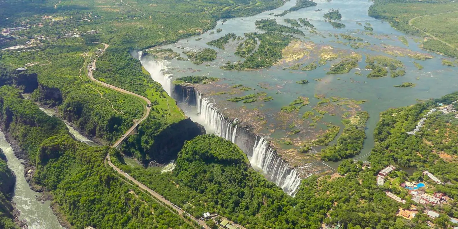 Aerial view of Victoria Falls from helicopter, showing full width of the falls and the Zambezi Gorge below